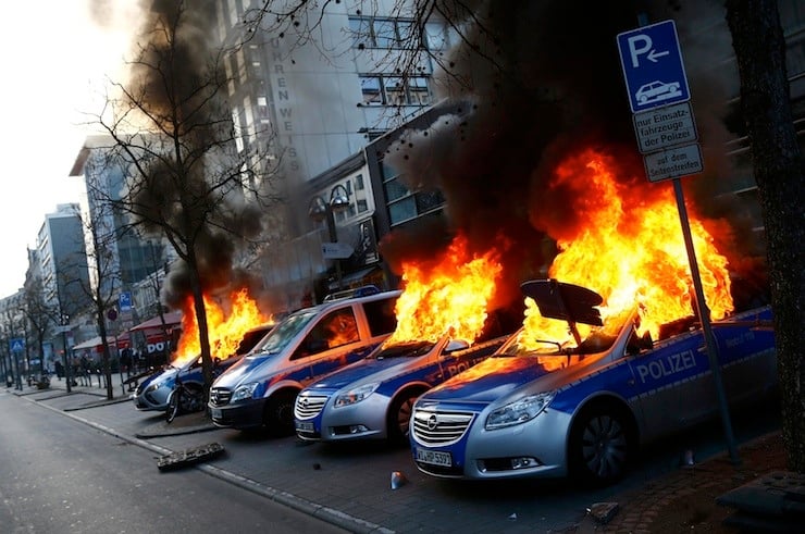 Four German police cars set on fire by anti-capitalist protesters burn near the new ECB headquarters in downtown Frankfurt