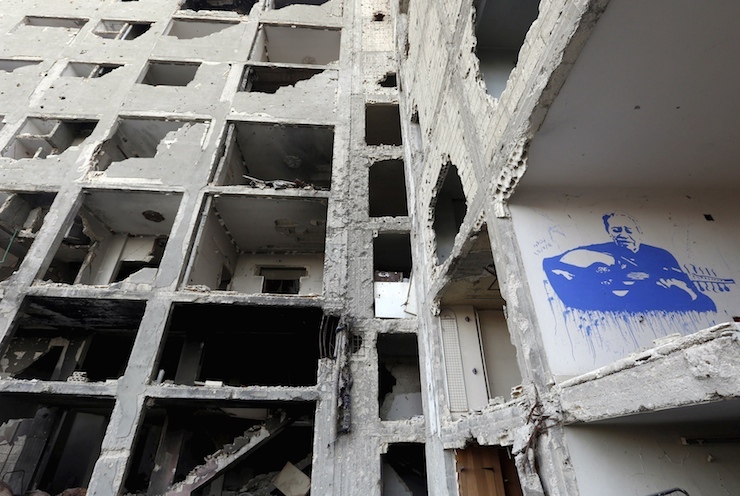 Graffiti is seen on a damaged building near Khaled Ibn al-Waleed mosque in Homs