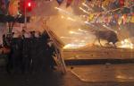 Riot policemen shield themselves as fireworks thrown by protesters explode next to the statue of a bull, during an anti-government protest in Kadikoy