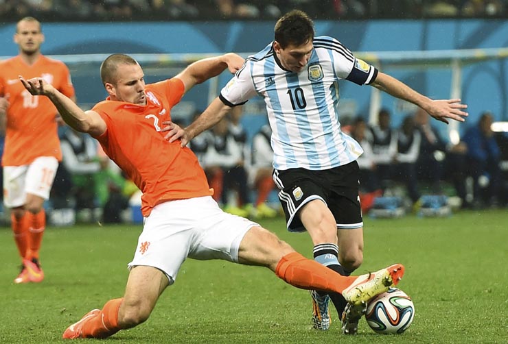 Janmaat of the Netherlands fights for the ball with Argentina's Messi during their 2014 World Cup semi-finals at the Corinthians arena in Sao Paulo