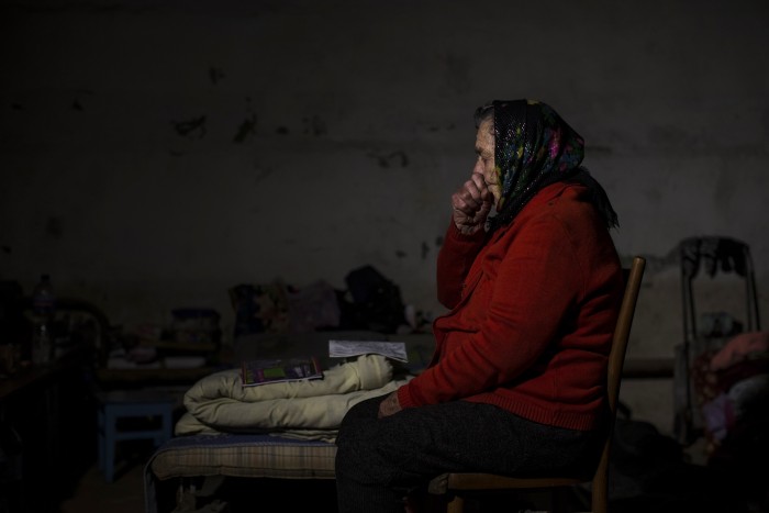 A woman sits inside a basement used as a shelter from the recent shelling in the town of Yasinovataya
