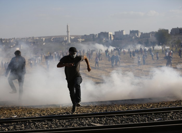 Turkish security forces use tear gas to disperse Turkish Kurds near the Mursitpinar border crossing near town of Suruc
