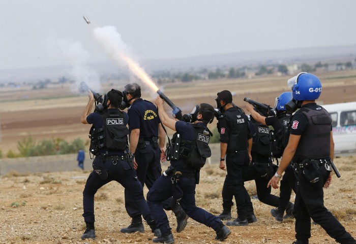 Turkish riot police fire tear gas to disperse pro-Kurdish protesters near the Turkish-Syrian border in the southeastern town of Suruc in Sanliurfa province
