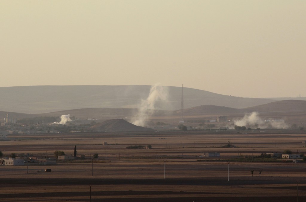 Smoke rises from the Syrian town of Kobani during what activists said were clashes between Islamic State fighters and Kurdish fighters, as seen from a hill in Tal-Hajeb village that overlooks the town