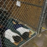 Two female detainees sleep in a holding cell as the children are separated by age group and gender at the U.S. Customs and Border Protection Nogales Placement Center in Nogales Arizona