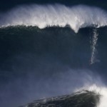 A surfer drops in on a large wave at Praia do Norte, in Nazare