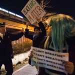 Policeman grabs a protester, who was demanding justice for the death of Eric Garner, as he was marching along the West Side Highway in Manhattan, New York