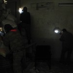 Rebel fighters take positions inside a room as they aim their weapons through holes in a wall in the old city of Aleppo near the frontline against forces loyal to Syria's President al-Assad