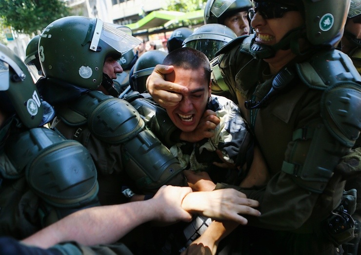 Student is detained during a demonstration near the Ministry of Education at Santiago