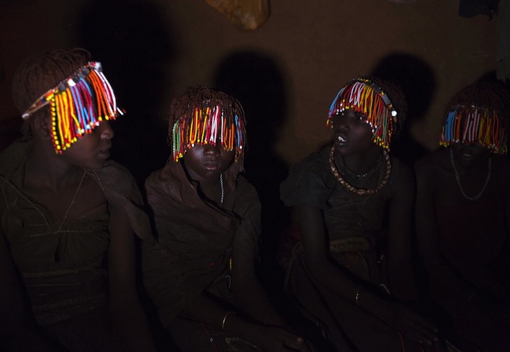 Pokot girls wearing beads and animal skins sit in a secluded hut one week prior to an initiation ceremony marking their passing over into womanhood, about 80 km (50 miles) from the town of Marigat in Baringo County