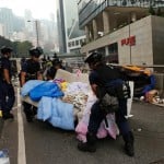 Police remove a sofa as they clear an area previously blocked by pro-democracy protesters near the government headquarters building at the financial Central district in Hong Kong