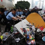 A policeman overturns a table as the area blocked by pro-democracy near the government headquarters building is being cleared at the financial Central district in Hong Kong
