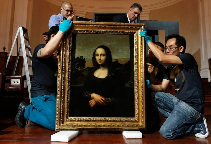 File picture of movers preparing to hang Leonardo da Vinci's "Early Mona Lisa" painting ahead of its exhibition at The Arts House in Singapore