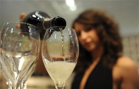 A woman fills glasses with sparkling wine at the Vinitaly wine expo in Verona