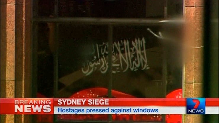 Video grab shows a black flag with white Arabic writing held up at the window of the Lindt cafe, where hostages are being held
