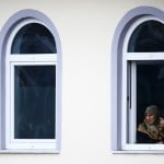 Women look out of a window of the mosque before a memorial service for late student Tugce A. in Waechtersbach