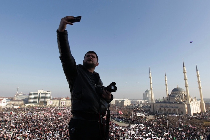 A man takes pictures of himself during a rally to protest against satirical cartoons of prophet Mohammad, in Grozny, Chechnya