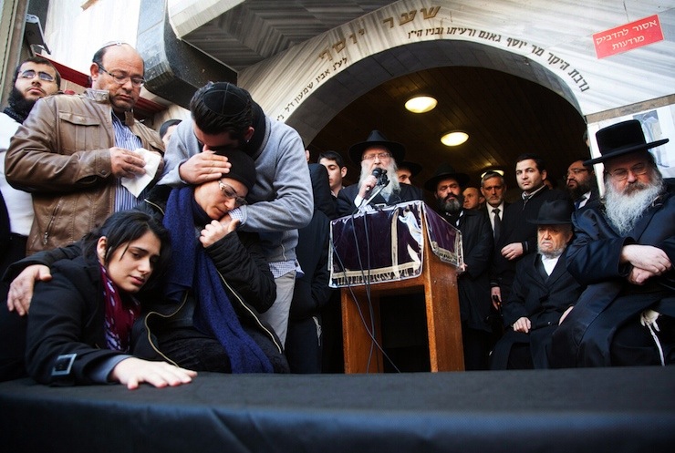 Family of victim of attack on a Paris grocery mourn beside a symbolic coffin during a procession near Tel Aviv