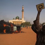 A man holds a copy of the Koran during a protest against Niger President Issoufou's attendance last week at a Paris rally in support of French satirical weekly Charlie Hebdo, in Niamey