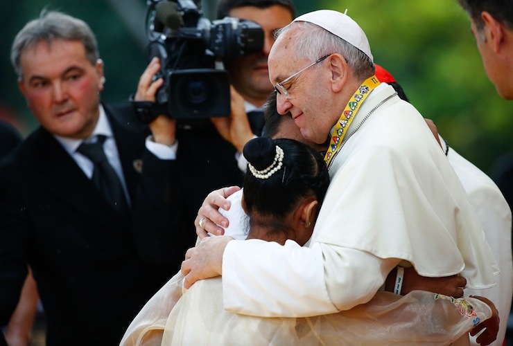 Pope Francis embraces a boy and a girl during a meeting with young people at Manila university
