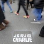 People walk past a grafitti tag reading “I am Charlie” as they take part in a solidarity march (Marche Republicaine) in the streets of Paris