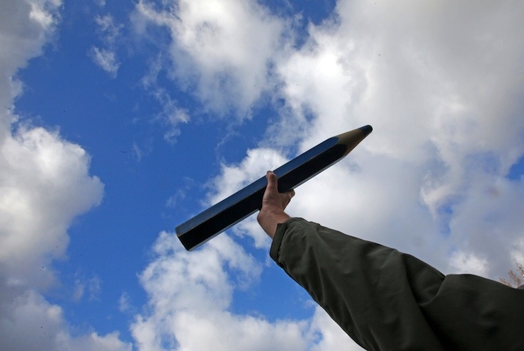 A man holds a pencil as he takes part in a solidarity march (Marche Republicaine) in the streets of Paris