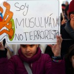 Girl holds a placard during a rally by members of the Muslim community of Madrid outside Madrid's Atocha train station