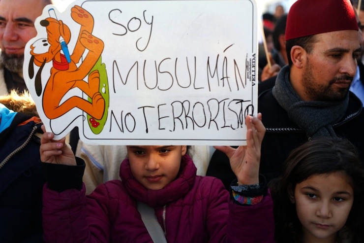 Girl holds a placard during a rally by members of the Muslim community of Madrid outside Madrid's Atocha train station