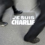 People walk past a grafitti tag reading “I am Charlie” as they take part in a solidarity march (Marche Republicaine) in the streets of Paris