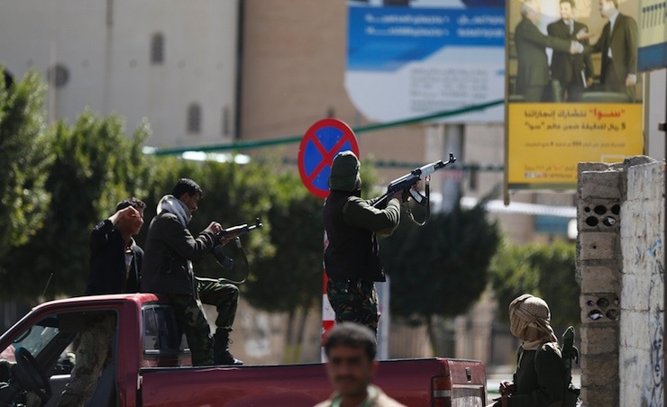 A Houthi fighter fires at forces guarding the Presidential Palace during clashes in Sanaa
