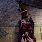 Bari Moumouch, a 20-year-old Berber mother, plays with her new born child in the village of Ait Sghir in the High Atlas region of Morocco