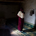 Bari Moumouch, a 20-year-old Berber mother, walks with her new born child on her back in the village of Ait Sghir in the High Atlas region of Morocco
