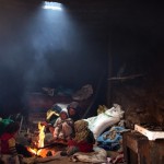 A woman and her children warm themselves around a fire in their home in Tilmi village in the High Atlas region of Morocco