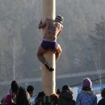 A man climbs up a 13-metre-high wooden pole to to get a prize during Maslenitsa celebrations at a ski resort in Krasnoyarsk