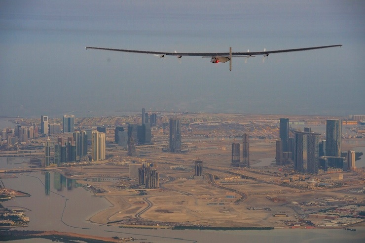 The Solar Impulse 2, a solar-powered plane, flies over the landscape of Abu Dhabi