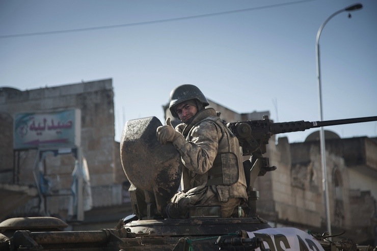 A Turkish soldier rides a tank in the northern Syrian town of Kobani
