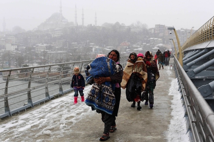 Syrian refugees brave the cold and snow as they walk to a metro station in Istanbul