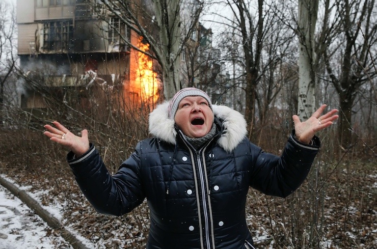 A woman reacts as the residential block in which she lives in burns, a result of recent shelling according to locals, on the outskirts of Donetsk, eastern Ukraine