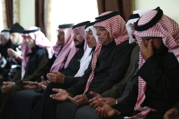 Saif al-Kasaesbeh, father of Jordanian pilot Muath al-Kasaesbeh, prays at the family's clan headquarters with other mourners in the city of Karak