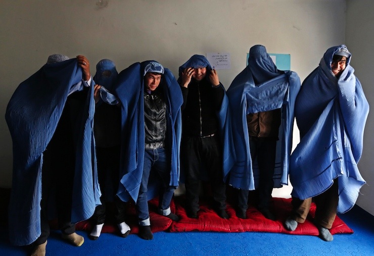 Male Afghan women's rights activist pose for media as they wear burqas to show their solidarity to Afghan women ahead of International Women's Day in Kabul