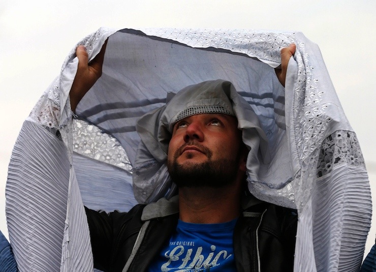 A male Afghan women's rights activist wears a burqa to show solidarity to Afghan women ahead of International Women's Day in Kabul