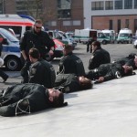 Riot police officers rest near ECB building before the official opening of it's new headquarters in Frankfurt