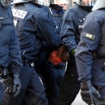 An anti-capitalist protester is detained by policemen near the ECB building before the official opening of its new headquarters in Frankfurt