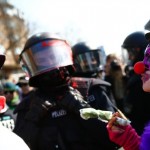 An anti-capitalist protester dressed as a clown gestures in front of a policeman near the ECB building before the official opening of its new headquarters in Frankfurt