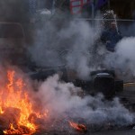 A resident extinguishes a burning barricade during a protest of members of 'Blockupy' anti-capitalist movement near the ECB building before the official opening of its new headquarters in Frankfurt