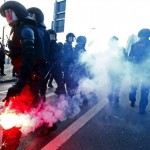 A policeman holds a flare during a protest of members of 'Blockupy' anti-capitalist movement near the ECB building before the official opening of its new headquarters in Frankfurt