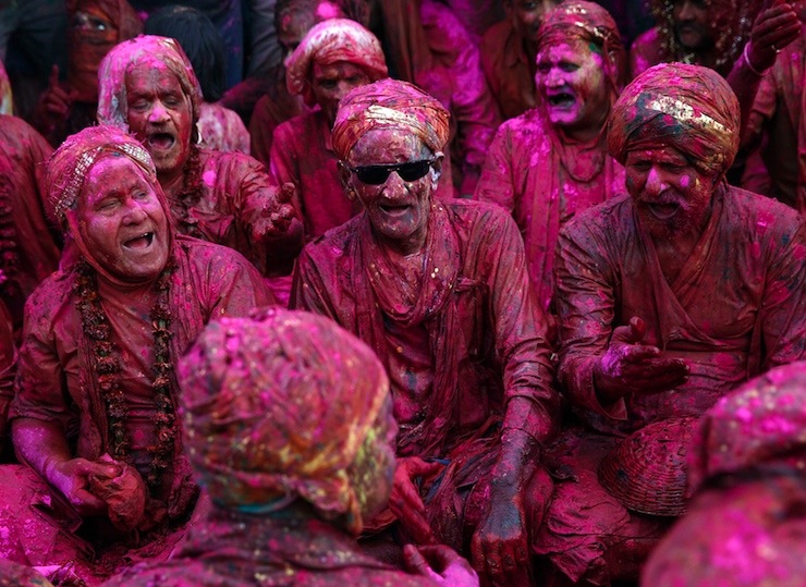 Men daubed in colours sing religious songs as they celebrate "Lathmar Holi" at Nandgaon
