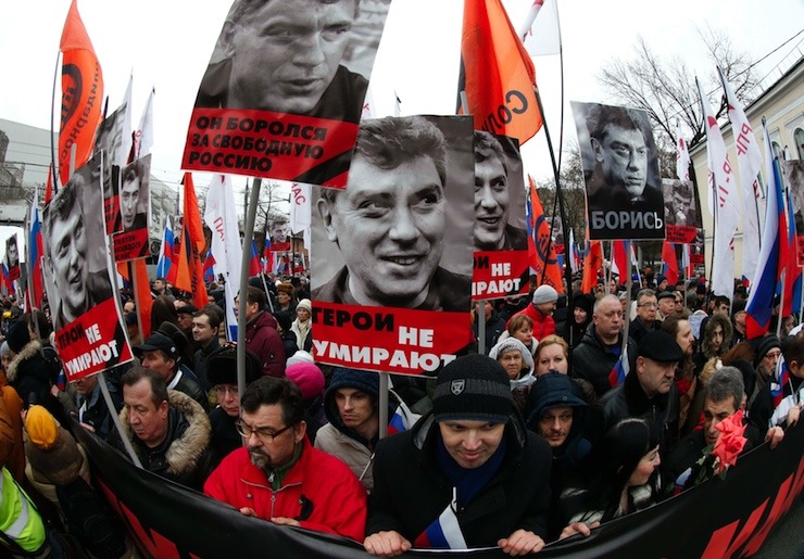 People hold flags and posters during march to commemorate Kremlin critic Nemtsov in central Moscow