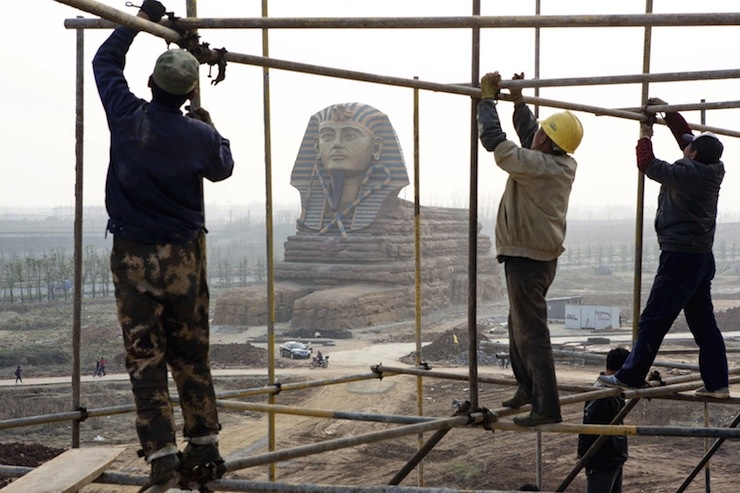 Labourers work on scaffolding near a full-scale replica of the Sphinx at an unfinished movie and animation tourism theme park, in Chuzhou