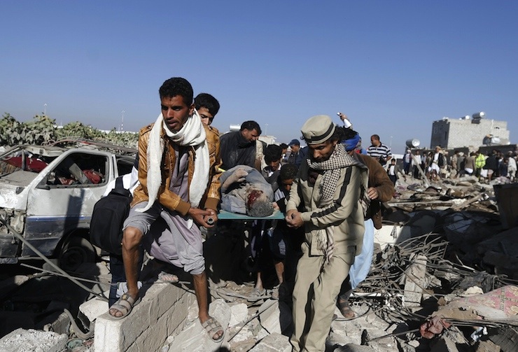 People carry the body of a man they uncovered from under the rubble of a house destroyed by an air strike near Sanaa Airport